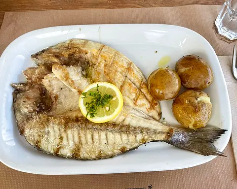 Grilled gilt-head bream, opened flat, with lemon and skin-on potatoes