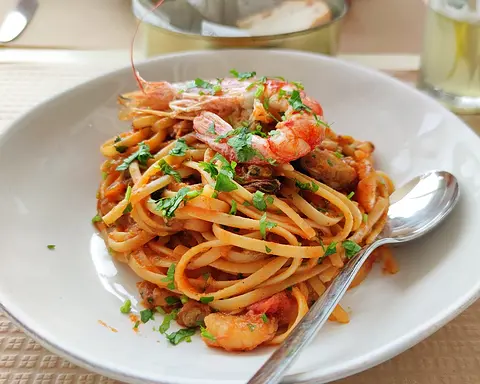 Spaghetti with prawns and parsley in a tomato seafood sauce