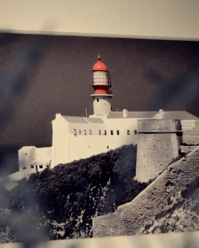 A framed black-and-white photograph of the Cabo de São Vicente lighthouse